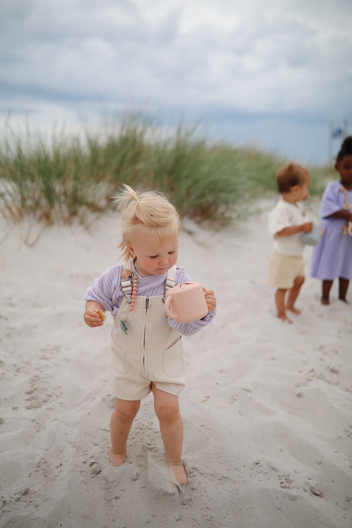 Girl at the beach with her sippy cup