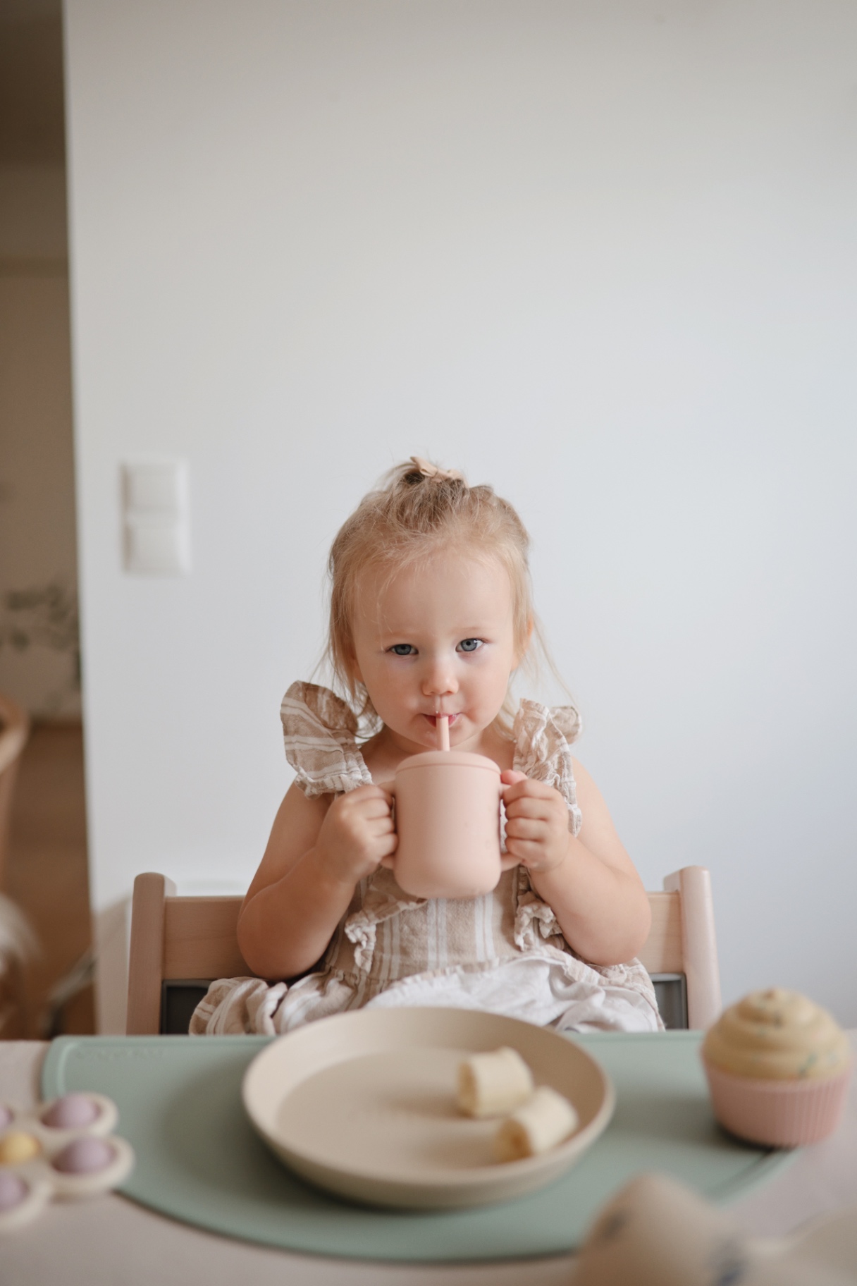 Girl drinking from a straw cup at the table