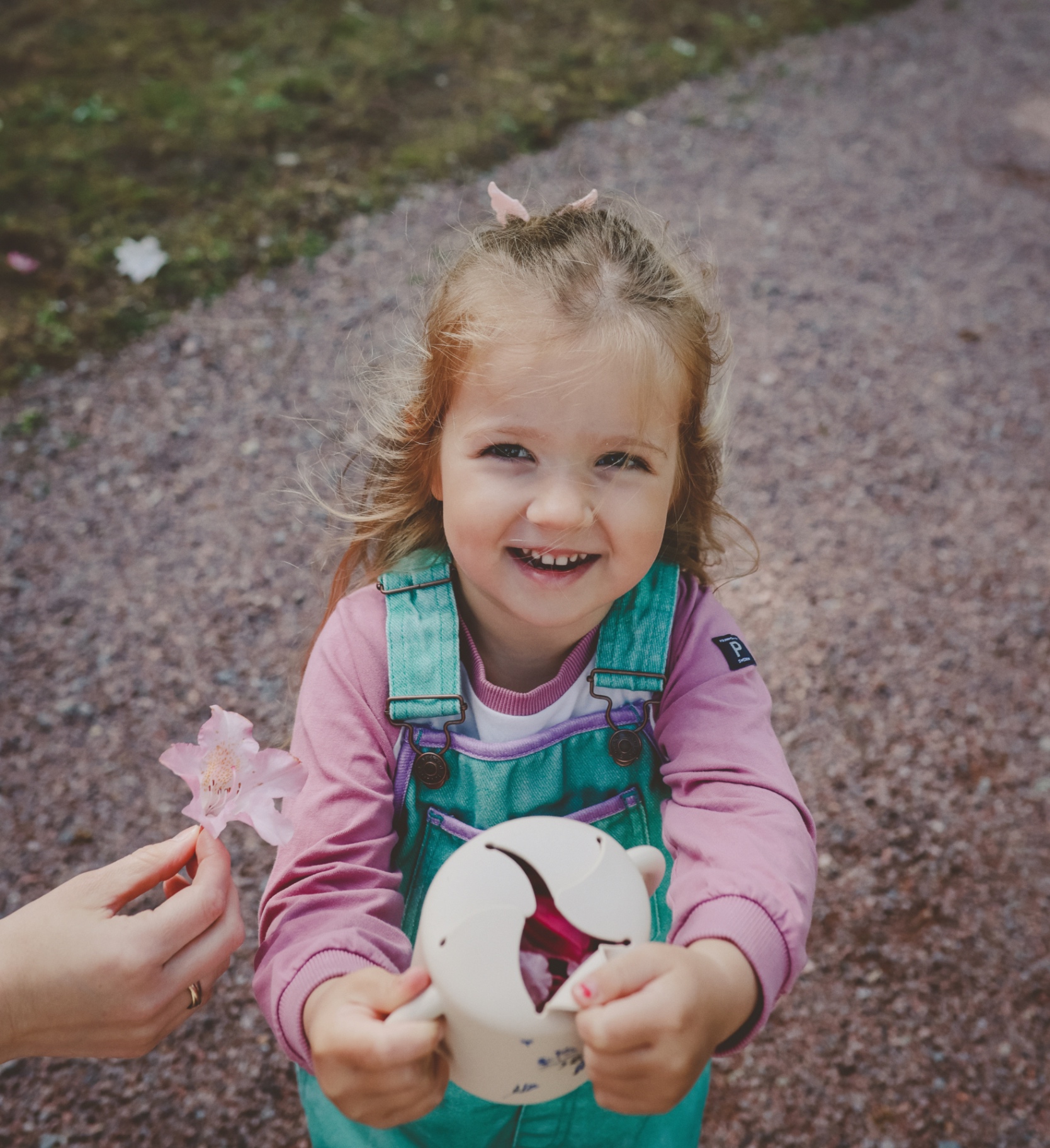 Toddler holding a silicone snack cup outdoors