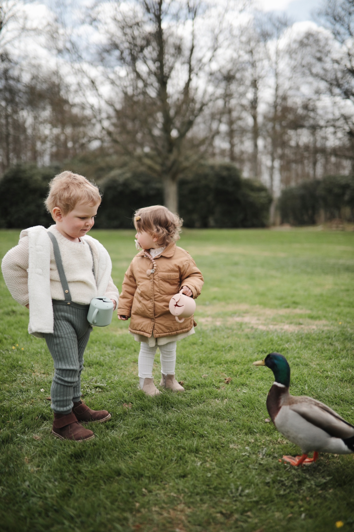 Children with silicone cups feeding a duck